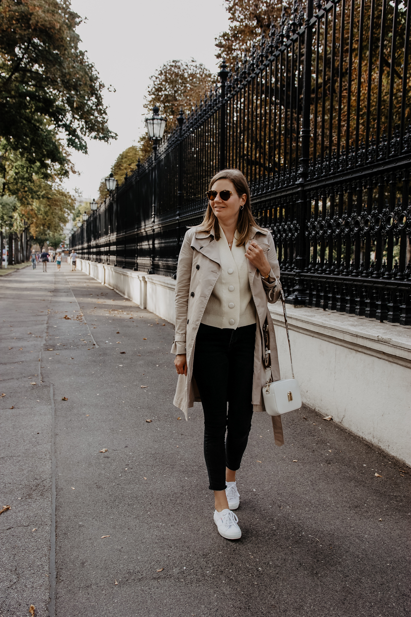 Trenchcoat mit Jeans und Sneakers