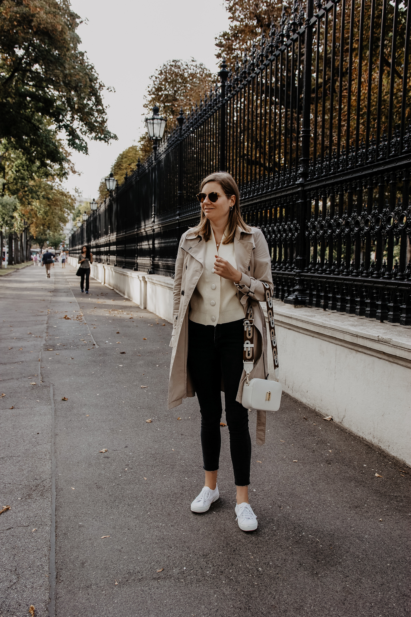 Trenchcoat mit Jeans und Sneakers